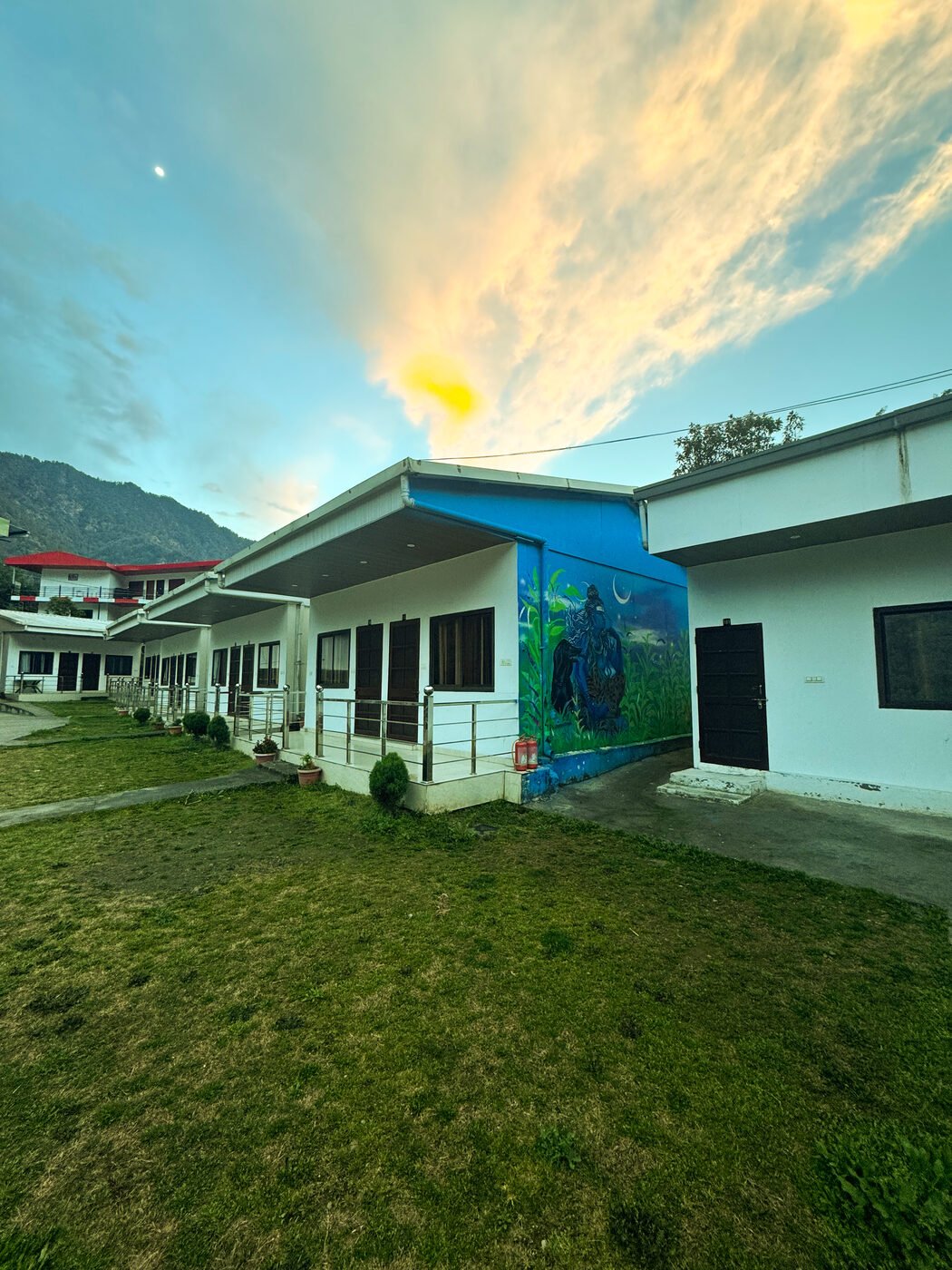 Shersi Heights Resort at sunset with mountain backdrop
